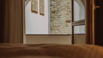 A room with a stone wall and arched windows.