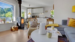Un salon moderne doté d’une cheminée, d’un coin repas et d’une cuisine.