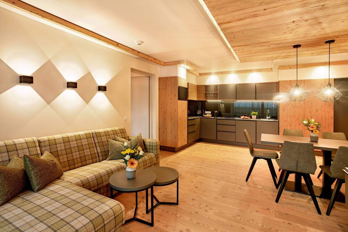 A modern living room with a sofa, coffee table, and dining area.