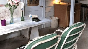 A dining area with a table, chairs, and a vase of flowers. - Quiet neighborhood near beaches, bayou and historic downtown Ocean Springs. (Ocean Springs)