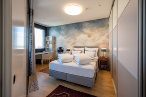 Une chambre à coucher moderne avec un grand lit, un bureau et une bibliothèque.