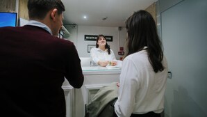 A reception area with a glass counter, a whiteboard, and a fire alarm on the wall. - Hotel Città di Parenzo (Trieste)