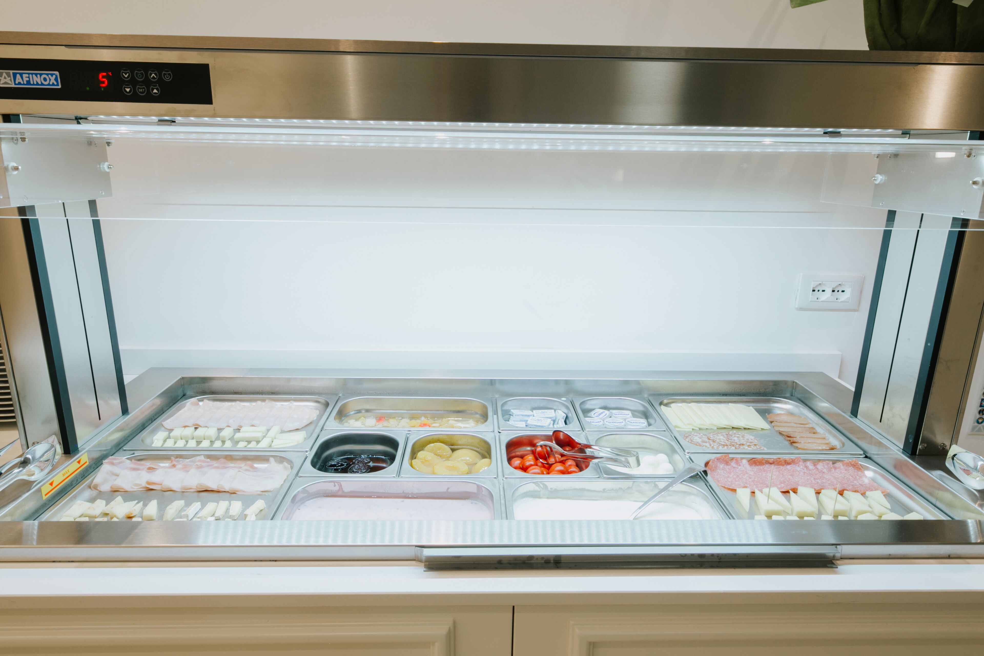 A buffet with various food items including meats, cheeses, and vegetables.