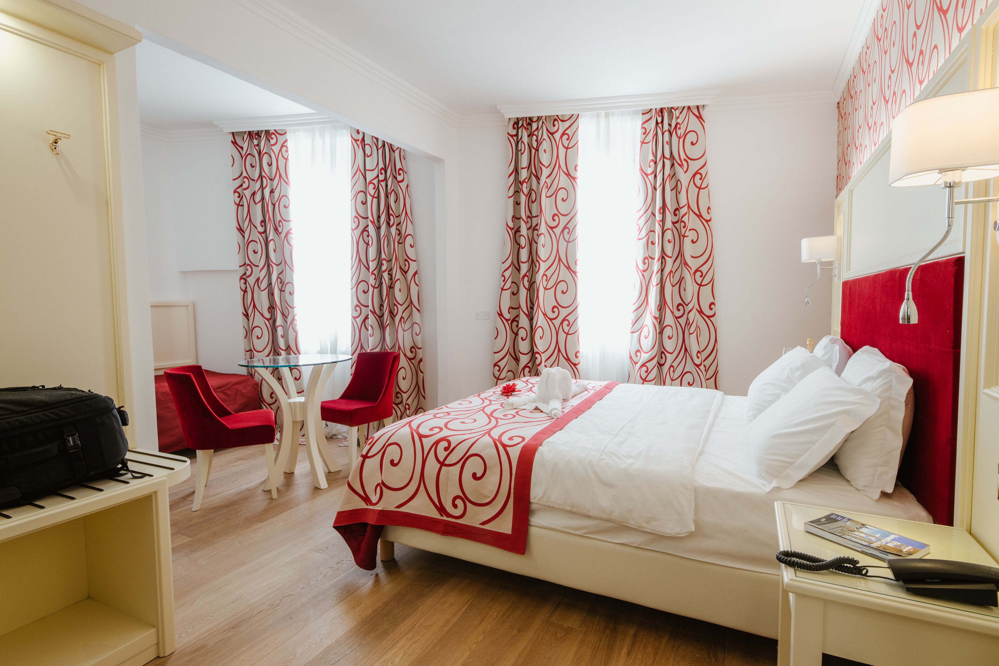 A hotel room with a bed, a desk, a chair, and a table.