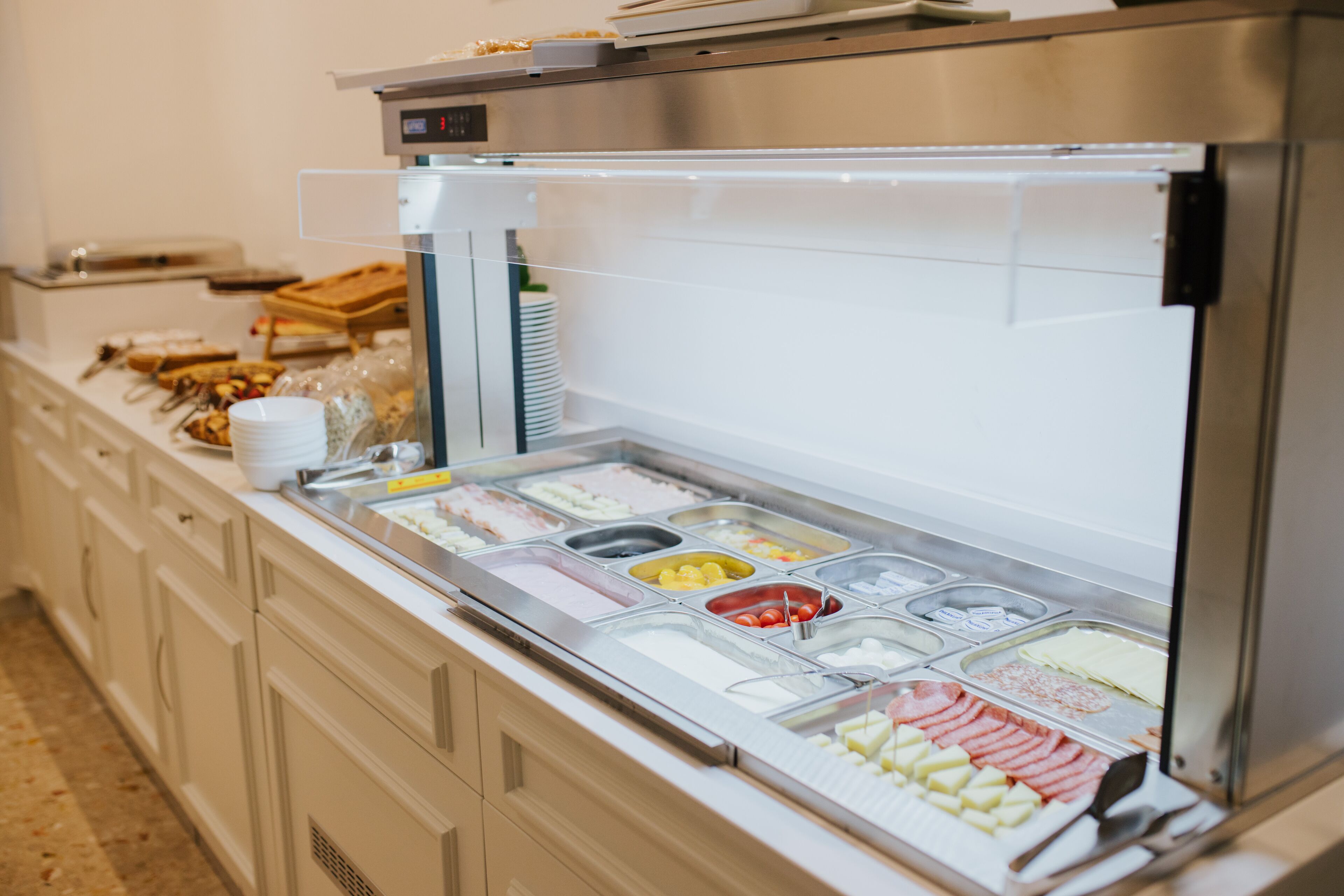 A buffet with various food items and a weighing scale.