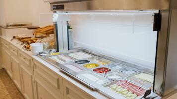 A buffet with various food items and a weighing scale.