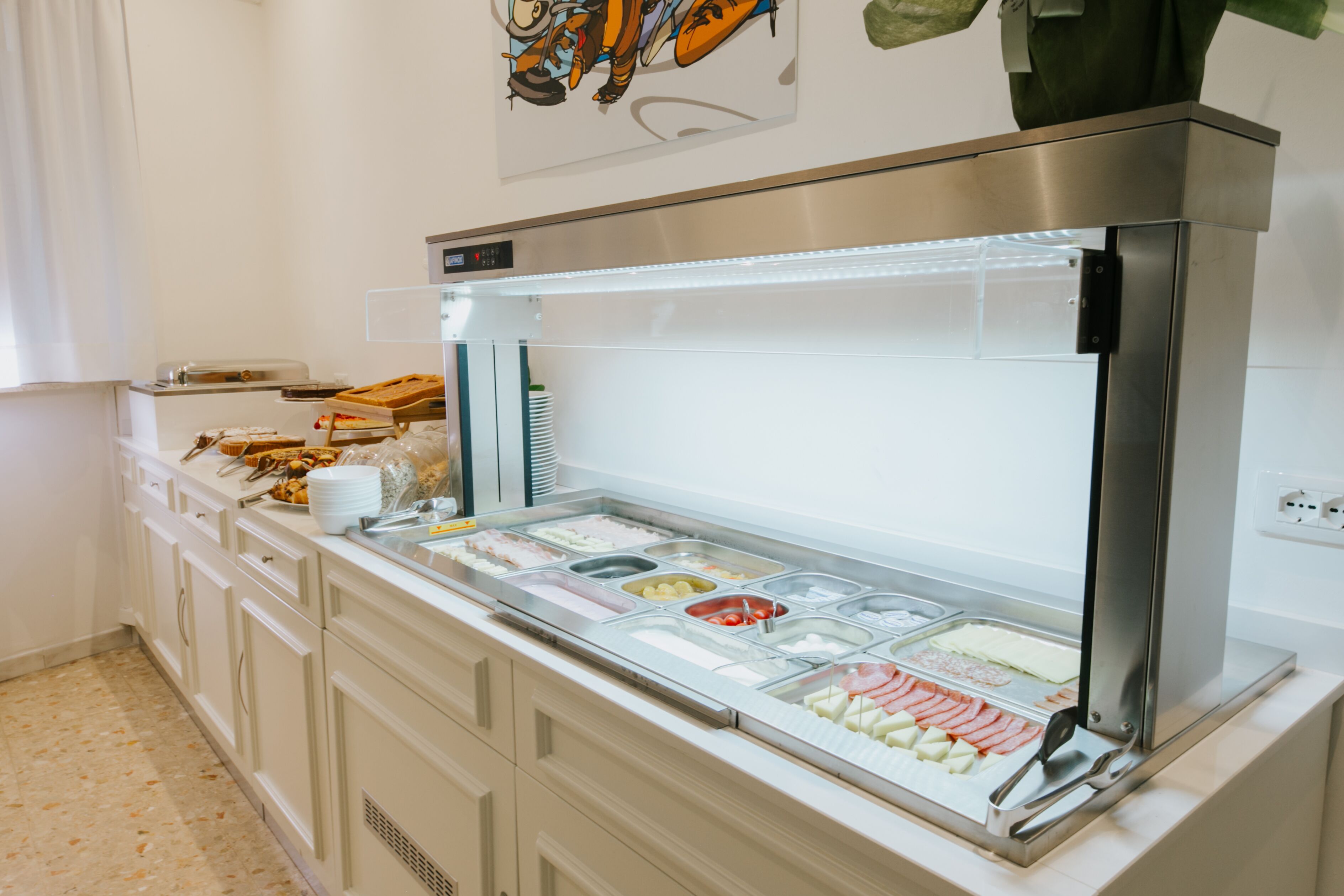 A buffet with various food items and a refrigerator.