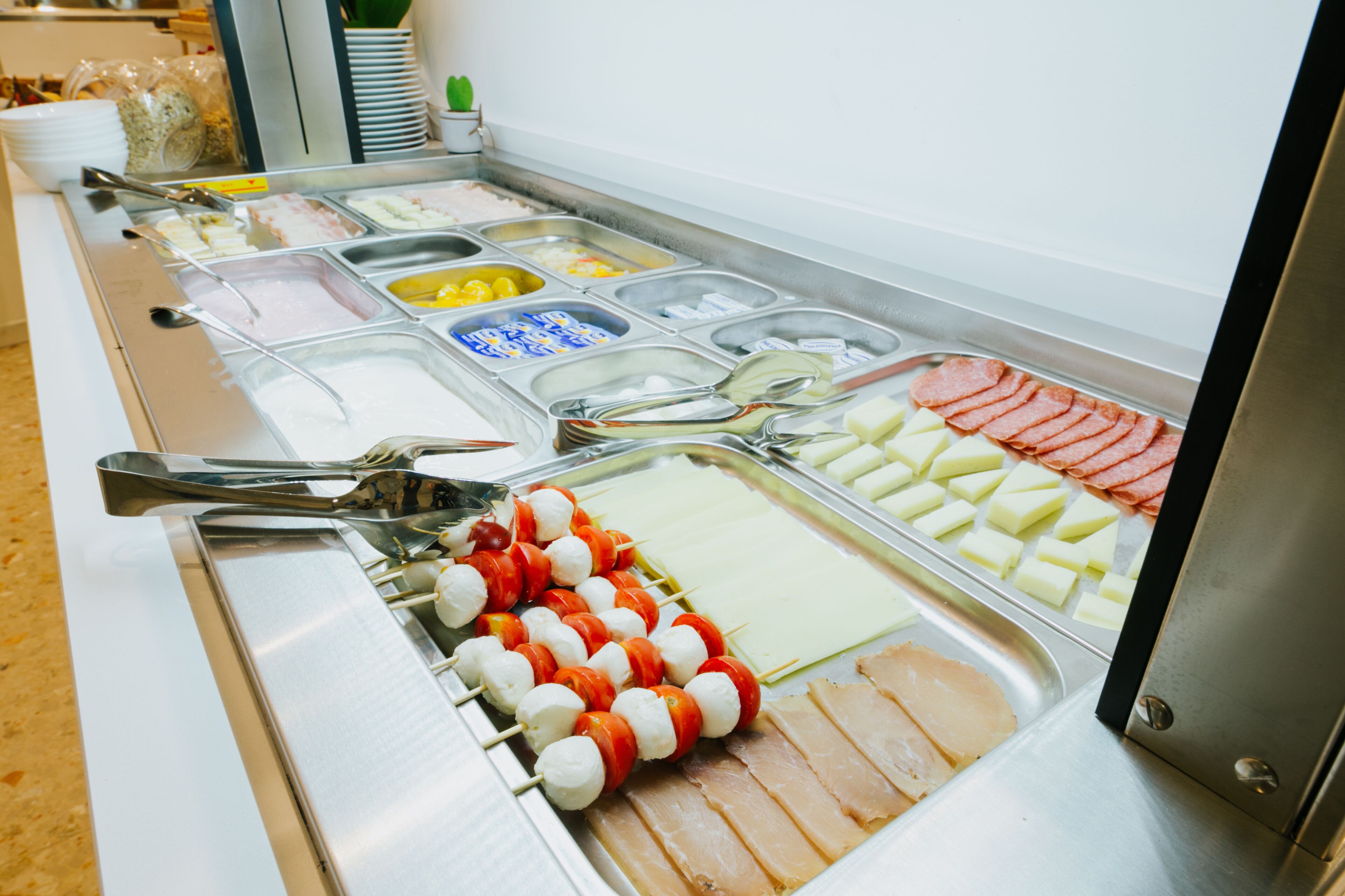 Ein Buffet mit verschiedenen Speisen, darunter Spieße, Käse und Aufschnitt.