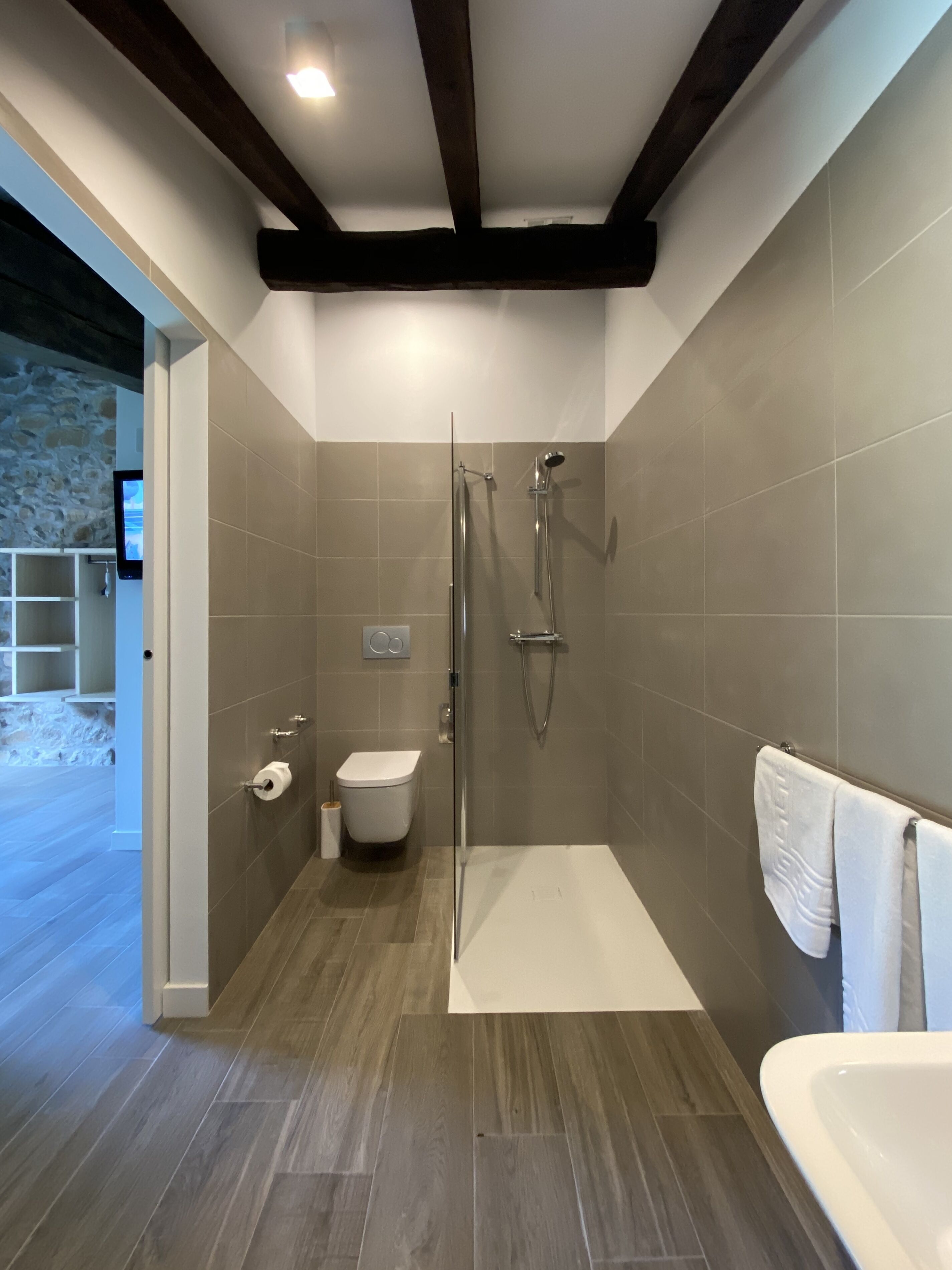 Une salle de bain moderne équipée d’une douche, de toilettes et d’un lavabo.