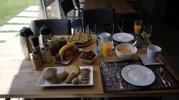 A breakfast table with various food items, including fruits, bread, and a pie, along with coffee and juice.