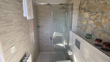 A bathroom with a shower, toilet, and sink.