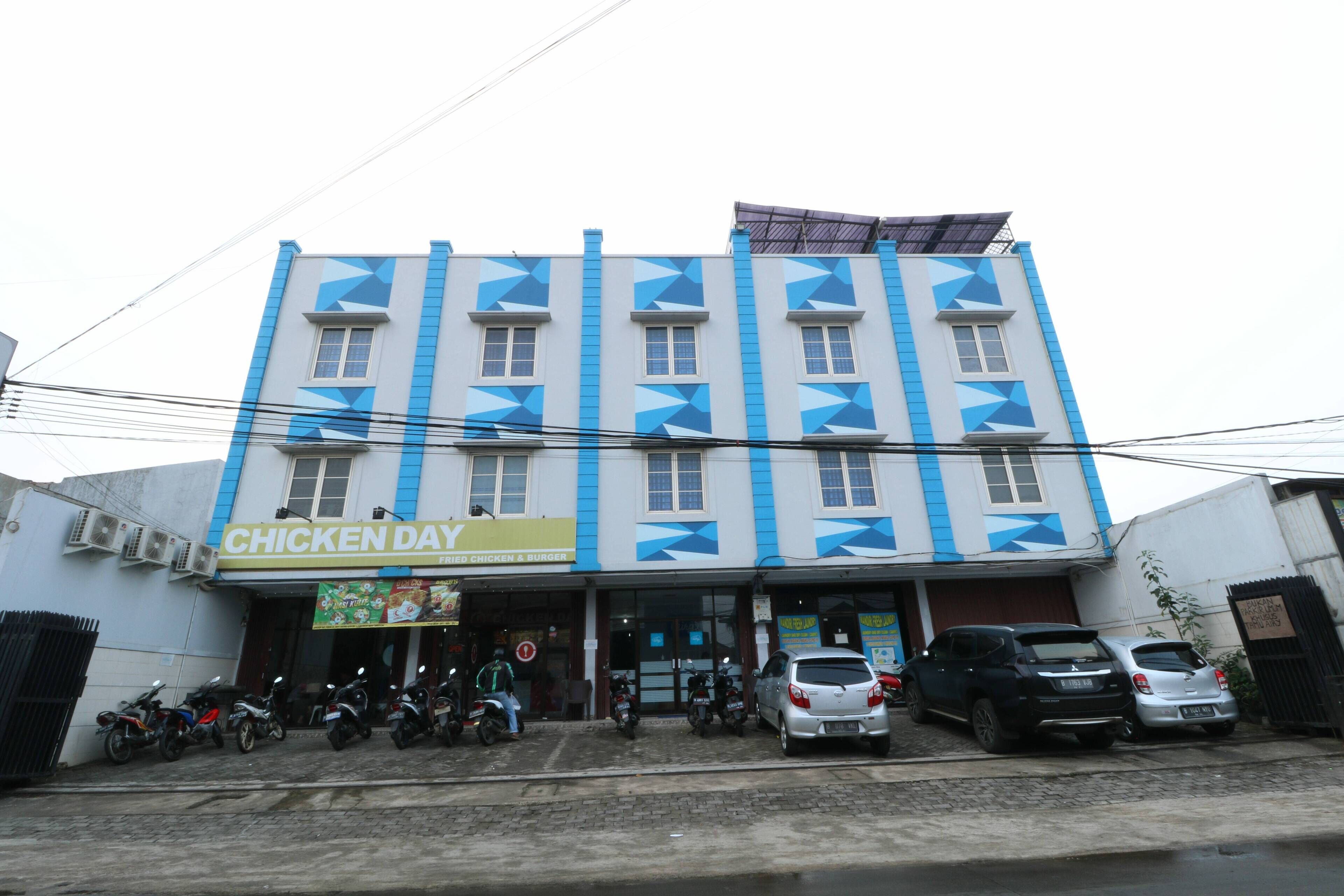 Un edificio con un letrero que indica el restaurante 'Chicken Day'.