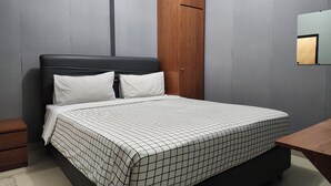 Un dormitorio con cama, armario de madera, mesita de noche y espejo en la pared.