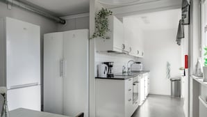 Una cocina moderna con armarios blancos, encimera negra y pileta de acero inoxidable.