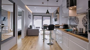 A modern kitchen with a wooden countertop, stainless steel appliances, and pendant lighting. - Goralski Szyk Royal Resort Wellness&SPA (Zakopane)