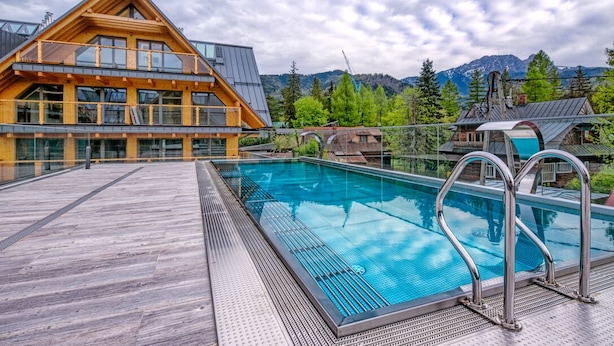 A wooden building with a pool and a deck. - Goralski Szyk Royal Resort Wellness&SPA (Zakopane)