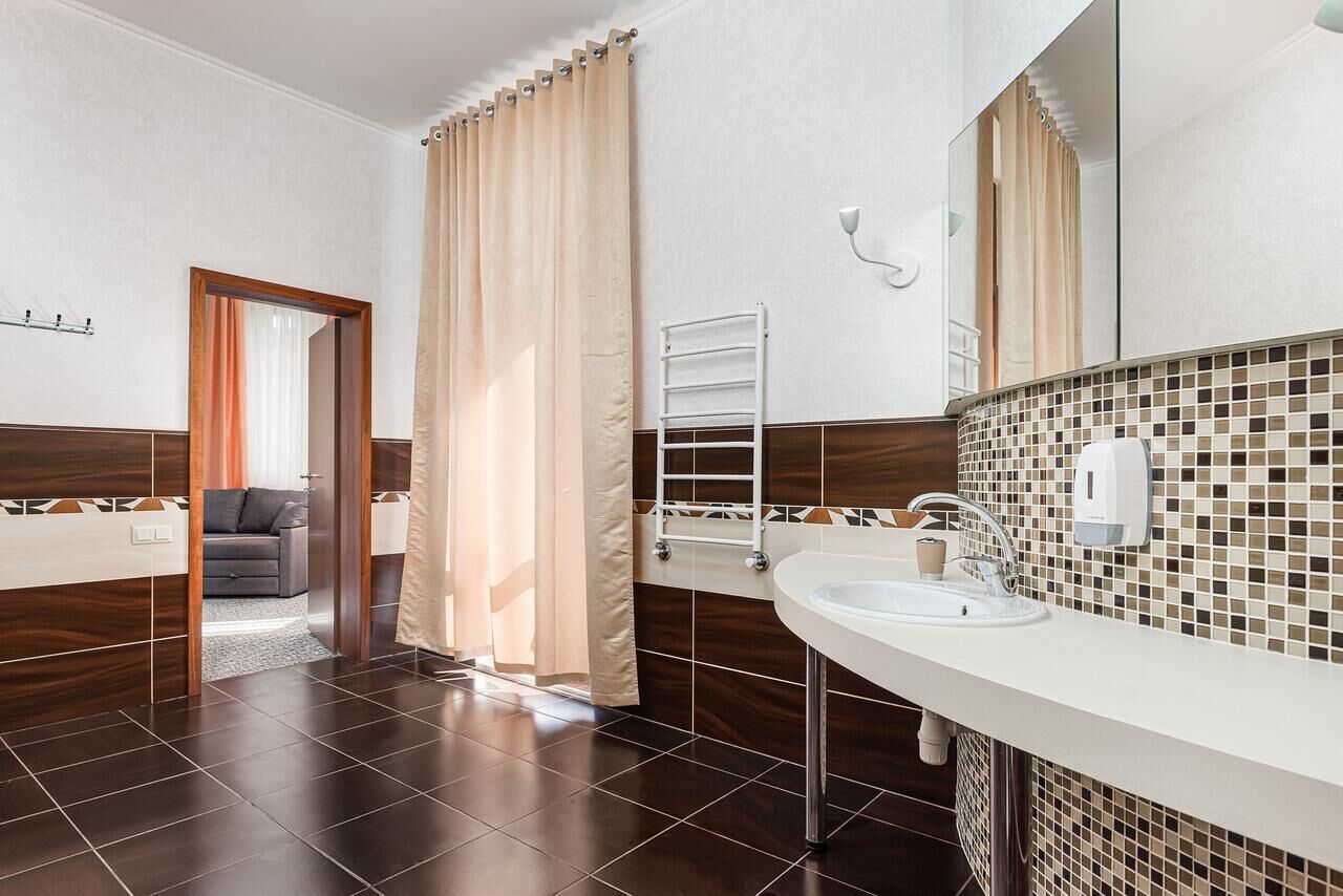 Un baño moderno con un espejo grande, un lavabo blanco y una zona de ducha.