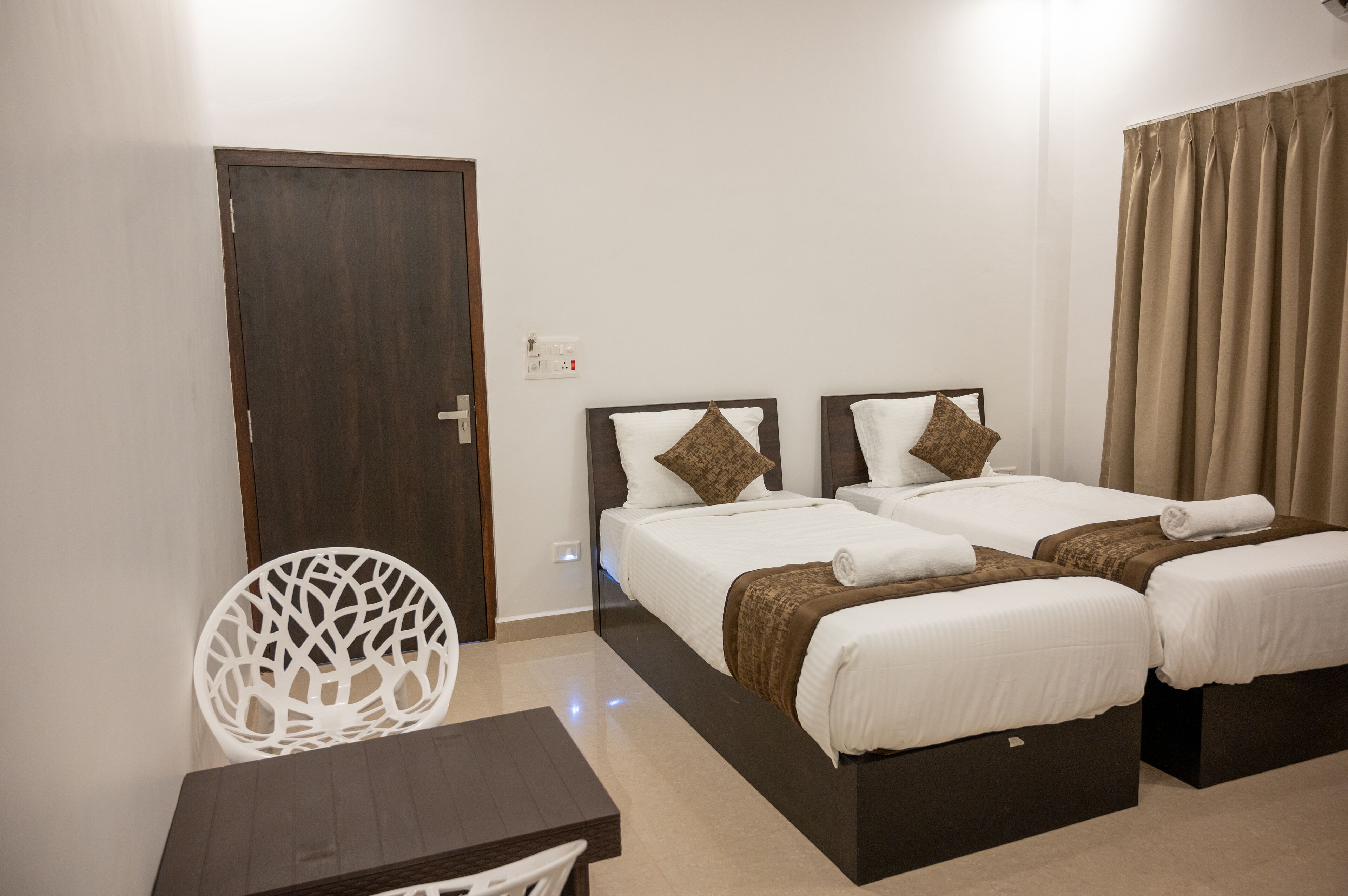 Una habitación de hotel con dos camas, un escritorio y una silla.