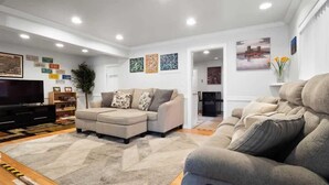 A modern living room with a sectional sofa, a flat-screen TV, and a large rug. - Sixth Street Victorian — Downtown Leadville (Leadville)