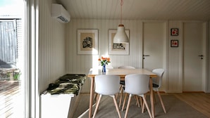 Et spiseområde med et bord, stole og en vase med blomster.
