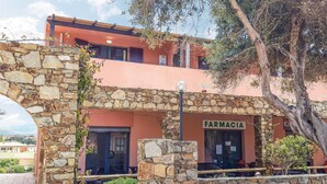 Un bâtiment à la façade en pierre, sur lequel on peut lire l’inscription « FARMACIA ».