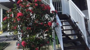 A two-story building with a covered staircase and a balcony. - Cosy nest - Plage de Babin (Morne-À-l'Eau Guadeloupe)