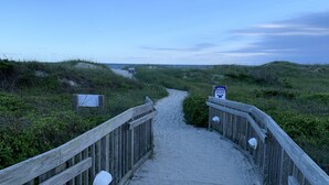 A wooden boardwalk leading to a beach with signs and a sandy path. - Wide, Sandy Beaches Await You! (Atlantic Beach)