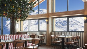 Un restaurante con vistas a la montaña, interior de madera y asientos a rayas.