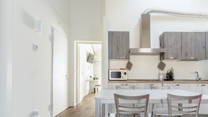 A modern kitchen with a central island, wooden cabinets, and a stainless steel range hood. - Casa Baci (Lazise)