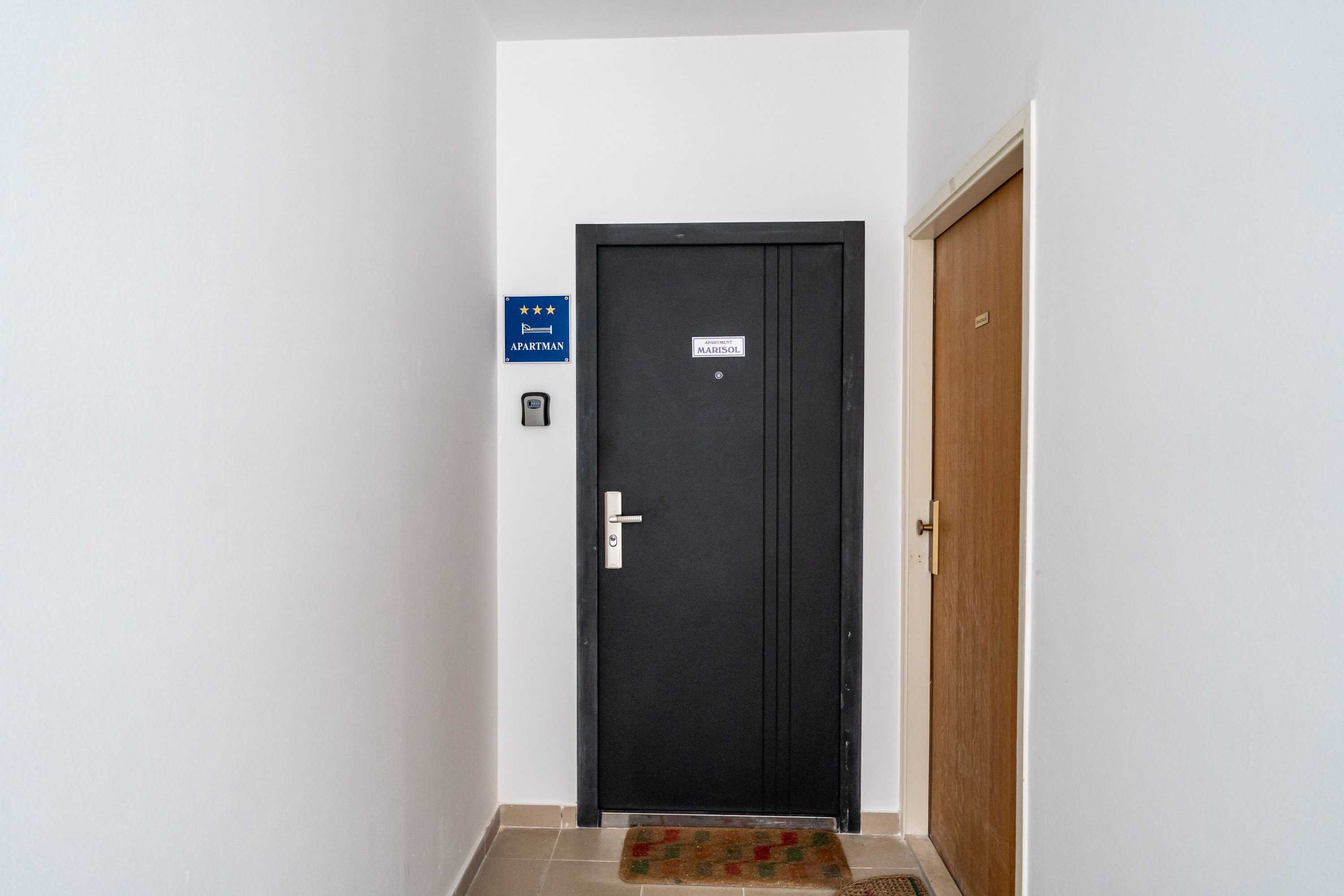A black door with a sign indicating it's an apartment.