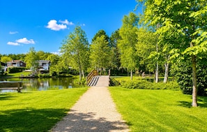 Un sendero que conduce a un lago, con casas al fondo.