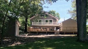 A two-story house with a deck and a covered patio area.