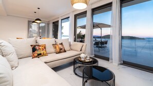 A modern living room with a sofa, a coffee table, and a view of the sea. - Villa Desire (Blato)