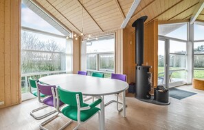 Enjoy a room with a high ceiling, wooden paneling, and a large table near a window offering a view of the outdoors.