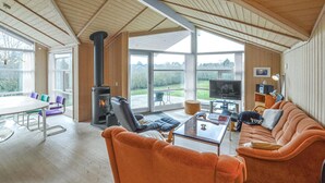 Una sala de estar acogedora con chimenea, un sofá, una mesa de centro y un televisor.
