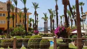 A resort with palm trees, a pool, and a view of the sea. - Marina Alcaidesa 2305 Luxury Golf House (San Roque)