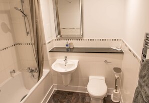 Bathtub, hair dryer, towels, shampoo
