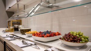 A buffet with various fruits and condiments.