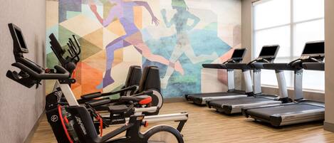 A gym with stationary bikes, elliptical machines, and treadmills.