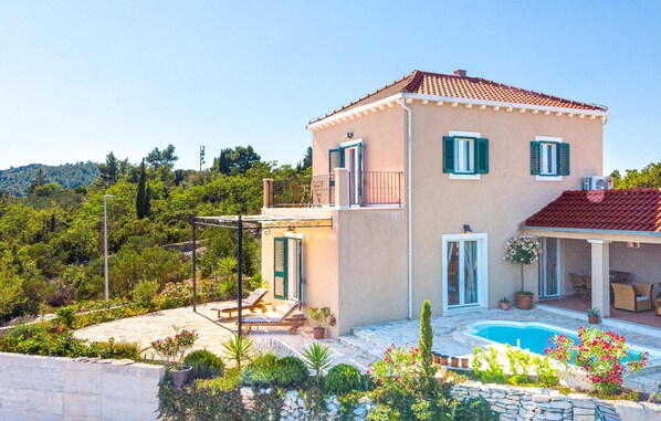 A two-story house with a swimming pool, surrounded by lush greenery and hills in the background. - Beach front home in Zrnovo (Zrnovo)