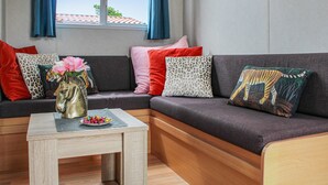A modern living room with a sectional sofa, a small wooden coffee table, and a vase with flowers.
