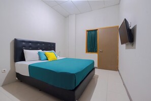 A bedroom with a bed, a television mounted on the wall, and a door with a curtain. - Athena Syariah Residence (Tangerang)