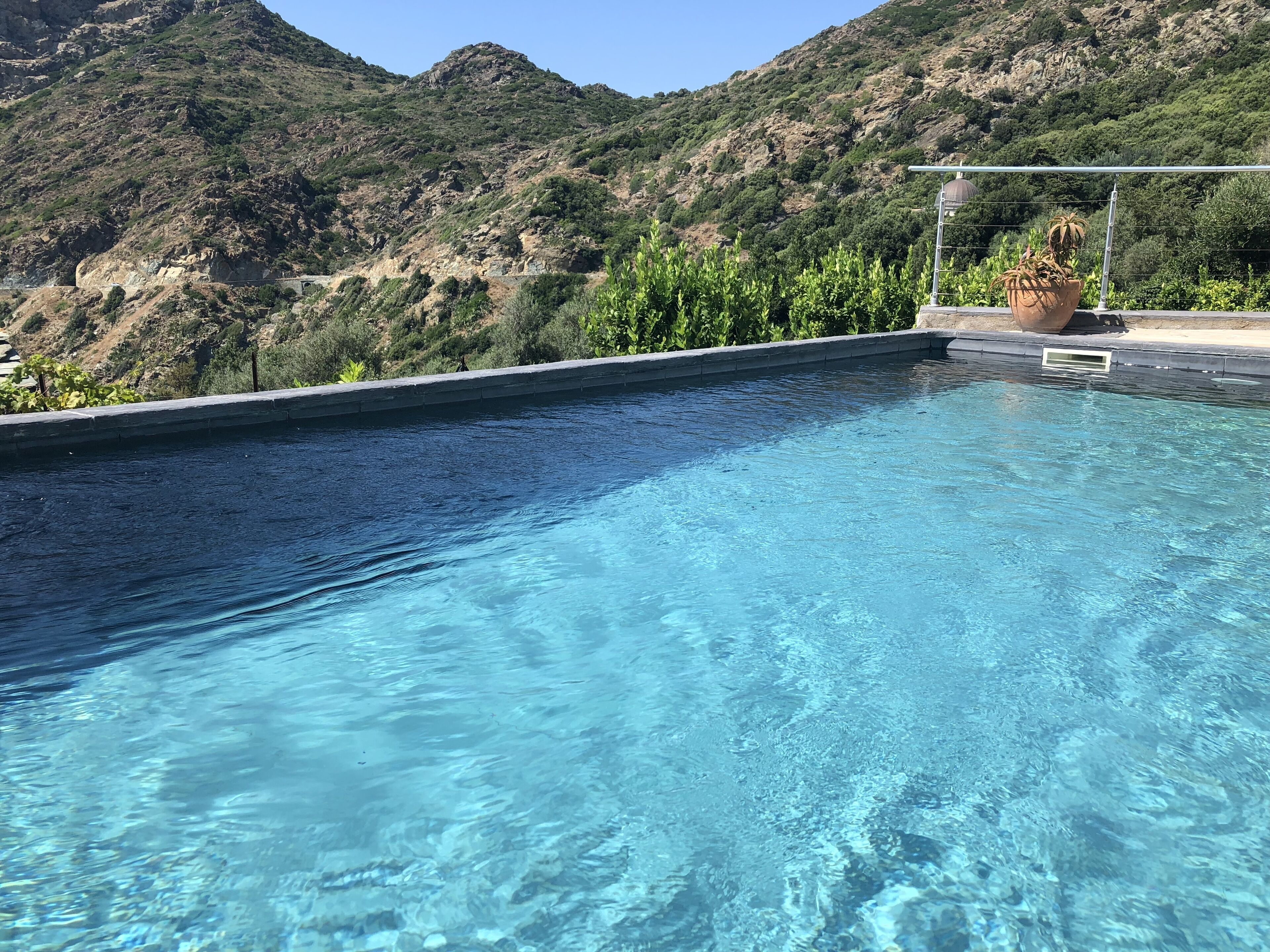 Une piscine d’eau cristalline, avec une chaîne de montagnes en toile de fond.