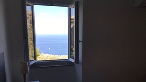 Ein Schlafzimmer mit Fensterblick auf Strand und Meer.