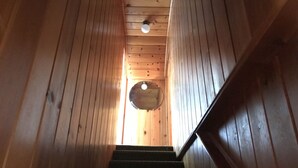 Eine Holztreppe führt zu einem runden Oberlichter.