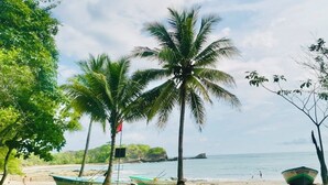 A beach with palm trees, boats, and a clear view of the ocean. - 3 min walking distance to Nosara beach (Guanacaste)