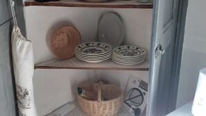 A kitchen with shelves holding various kitchenware, bottles, and a basket. - PERNES LA PROVENCALE (Pernes-les-Fontaines)