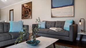 Una sala de estar moderna con dos sofás grises, una mesa de centro y un jarrón decorativo.