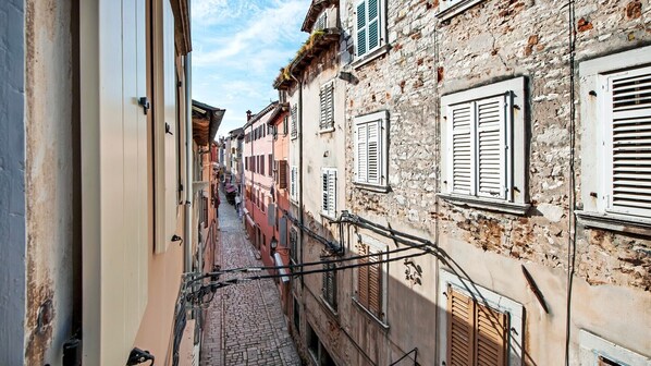 Eine enge Kopfsteinpflasterstraße, gesäumt von historischen Gebäuden mit traditionellen Fensterläden und Balkonen.