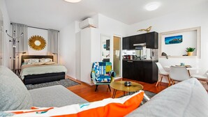 A modern apartment with a bedroom, living room, and kitchen area. - Studio Sunrise with Sea view (Rovinj)